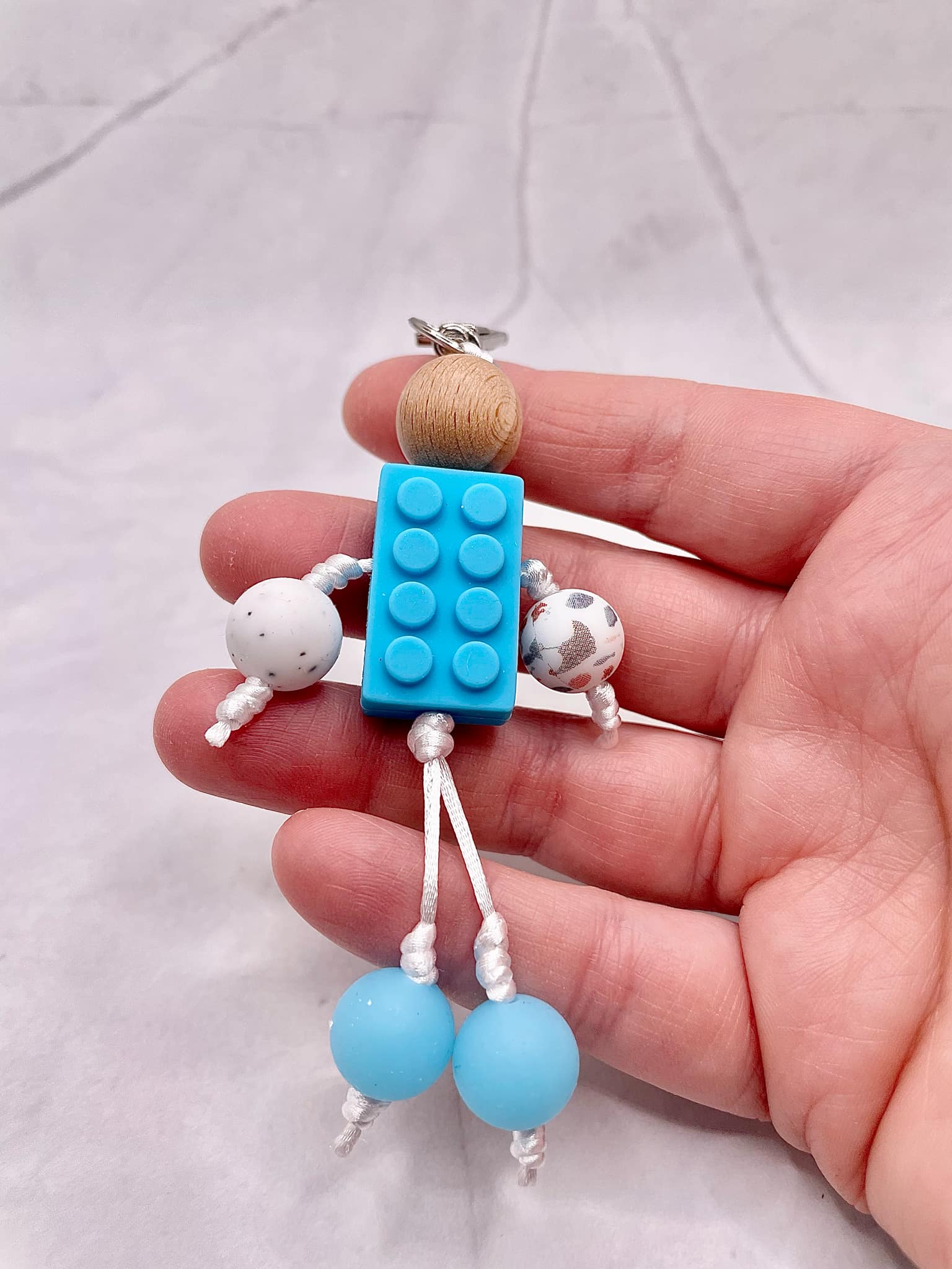 Bonhomme tissé à la main : ce porte-clés est un cordon tréssé avec perle silicone. Tissé à la main à travers différents fils de couleur, beau, unique et plein de créativité. Il peut être associé à un étui de téléphone, un sac à cartes, un portefeuille, une clé de voiture, un pendentif ou une petite poupée à suspendre pour enrichir d'autres fonctions d'utilisation.