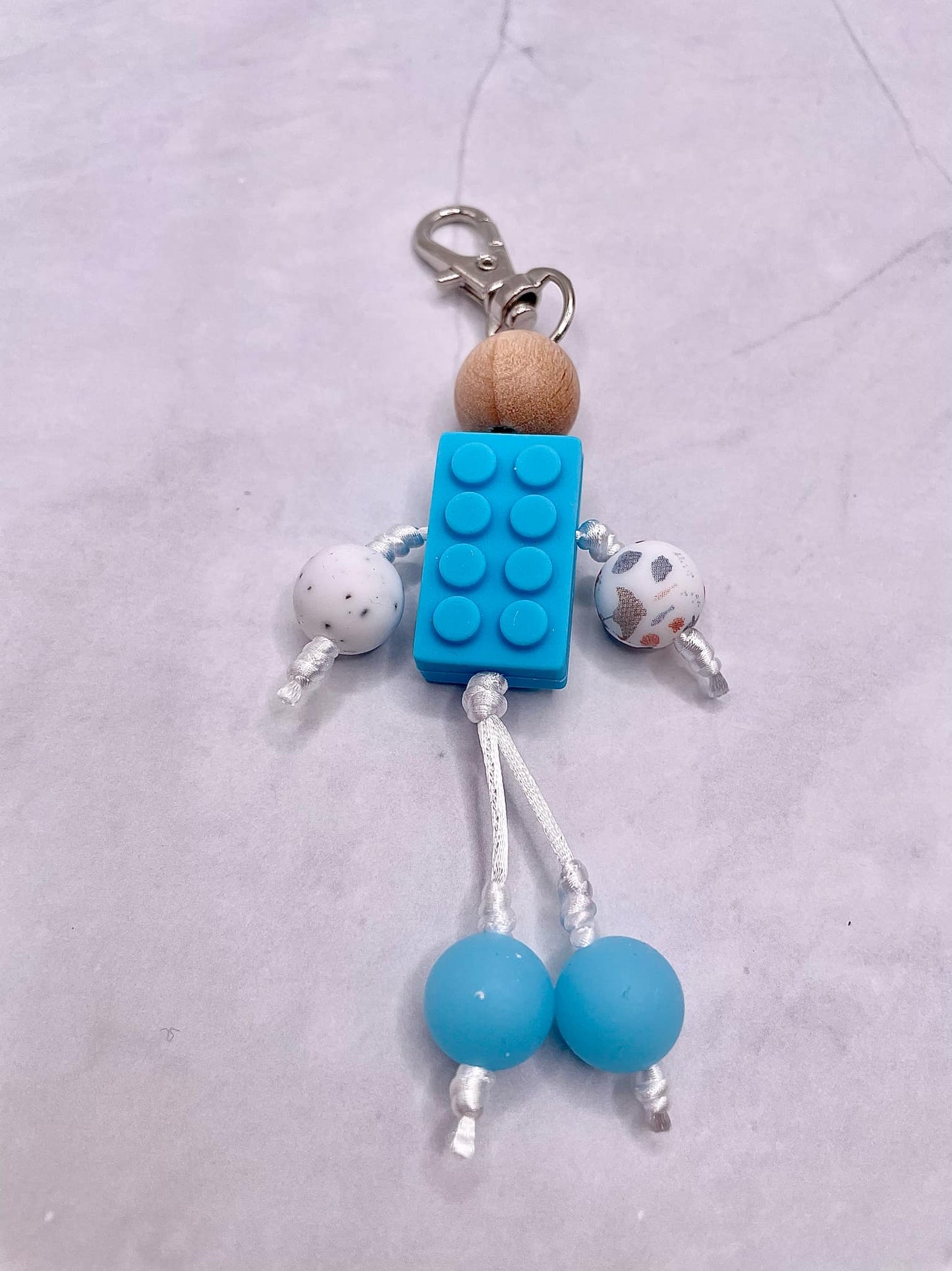 Bonhomme tissé à la main : ce porte-clés est un cordon tréssé avec perle silicone. Tissé à la main à travers différents fils de couleur, beau, unique et plein de créativité. Il peut être associé à un étui de téléphone, un sac à cartes, un portefeuille, une clé de voiture, un pendentif ou une petite poupée à suspendre pour enrichir d'autres fonctions d'utilisation.